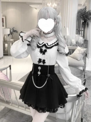 Jirai Kei off-shoulder blouse and pearl chain skirt set full body front view model wearing white ruffled lace blouse with black bows and black high-waist skirt