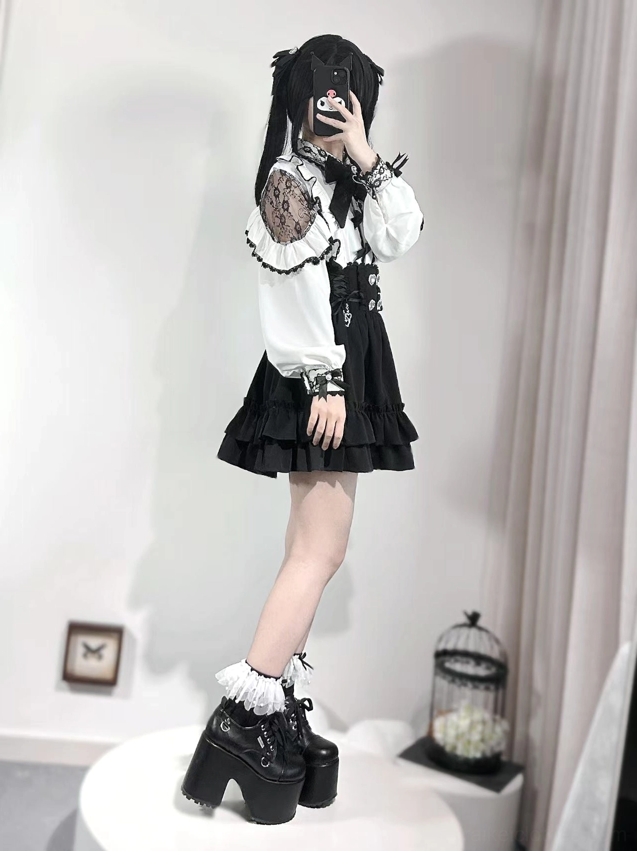 Jirai Kei blouse side profile on twin-tailed model wearing black platform block heels, lace sleeve panels, and frilly sock cuffs, studio platform setting