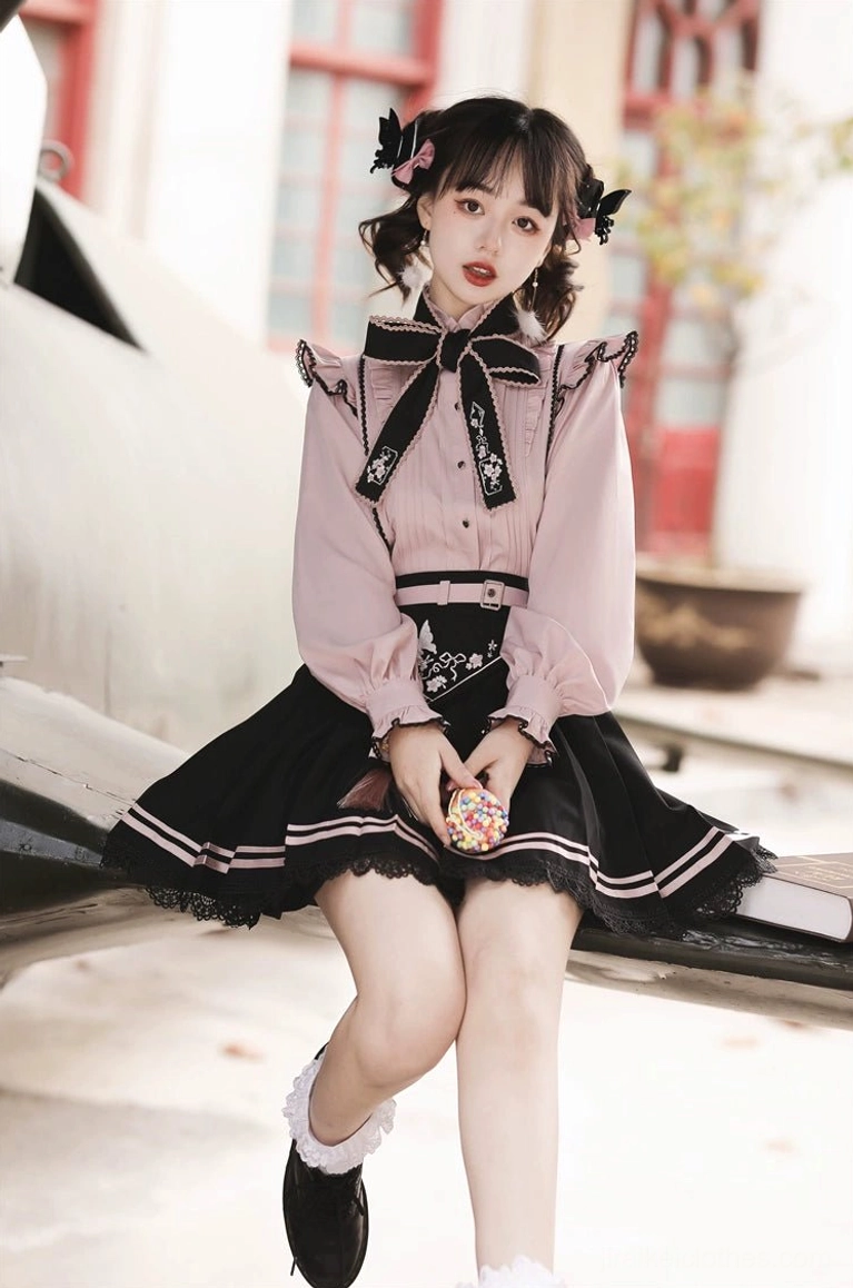 Full body seated shot of Jirai Kei two-piece ensemble with model holding candy prop, wearing white socks and loafers, outdoor bench background