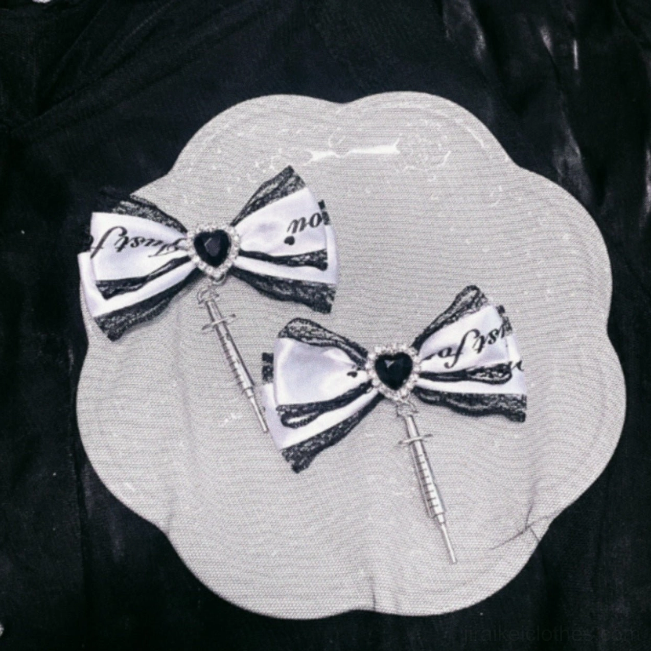 Pair of Jirai Kei bow accessories with bicolor printed ribbon, heart gem pendant, and syringe-shaped charm accent