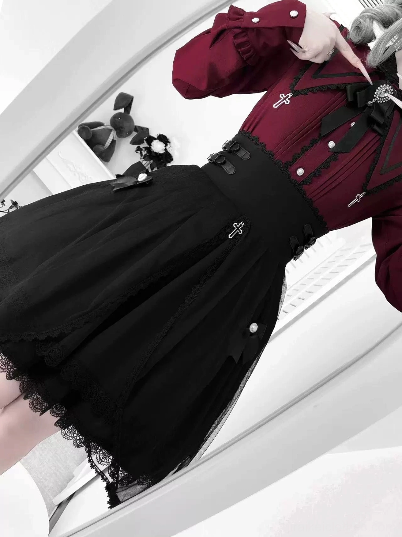 Close-up detail of Jirai Kei blouse highlighting burgundy colored peter pan collar with pointed lapels, removable bow detail, and cross brooch element with refined tailoring