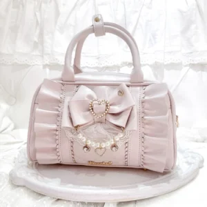 Pastel pink Jirai Kei 2-way handbag with ruched leather and detachable bow-pearl charm, front flat lay view on white lace backdrop