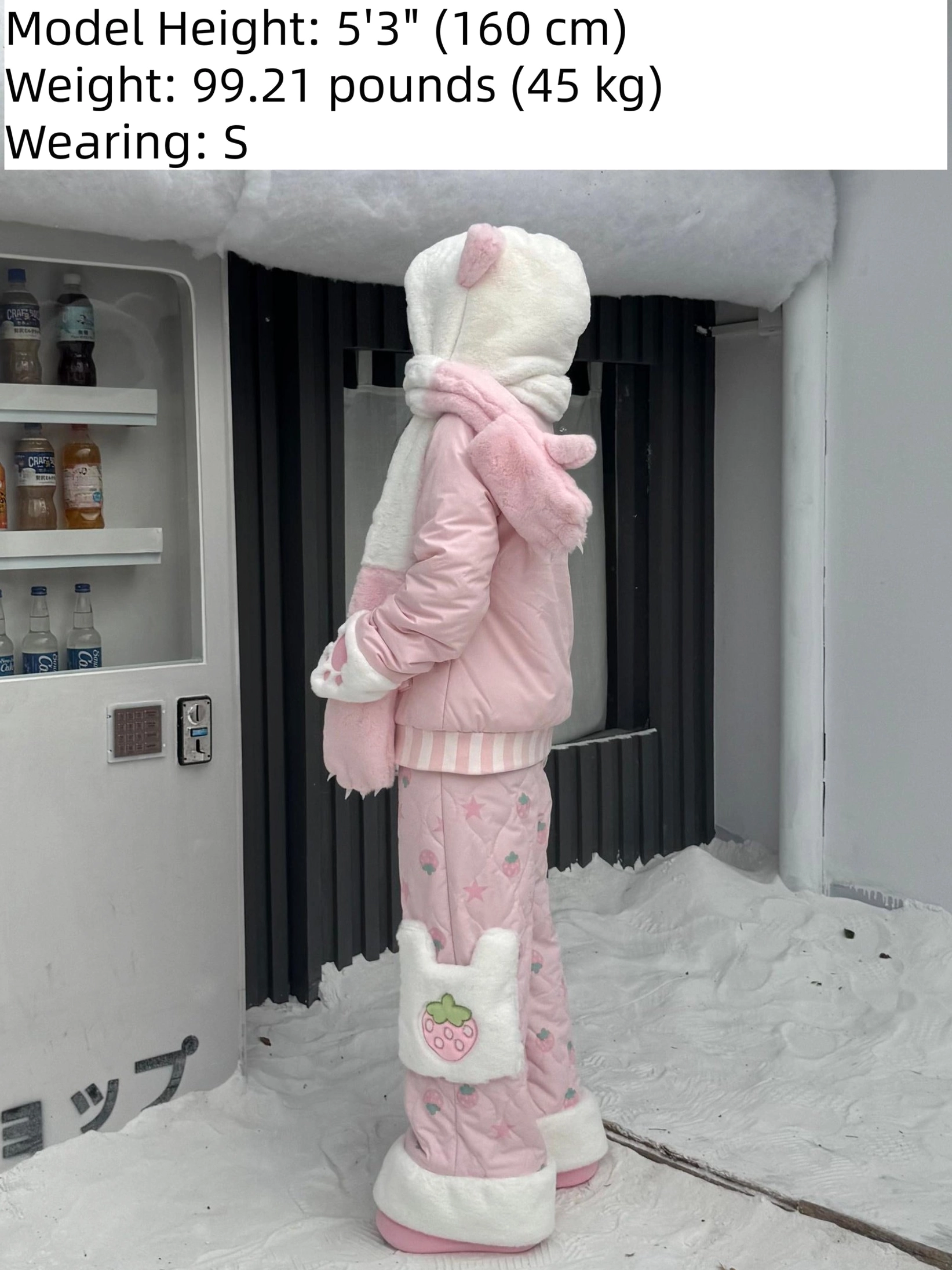 Back side view of pink Jirai Kei padded winter coat with bear ear hood, full fuzzy coverage, strawberry patch quilted pants, model size specifications display