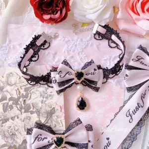 Jirai Kei pink-black bow choker necklace with teardrop rhinestone pendant and bow hair clip ornaments on lace fabric background