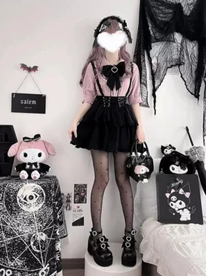Jirai Kei pink blouse with black suspender skirt lace-up design full front view worn by model with wavy pink hair and platform boots