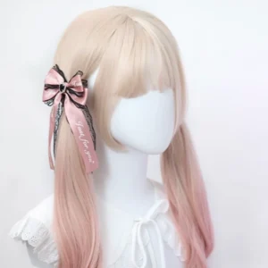 Pink satin bow Jirai Kei hair clip with printed slogan ribbon, lace trim and crystal accent, displayed on ombre twin-tail wig mannequin, right side perspective