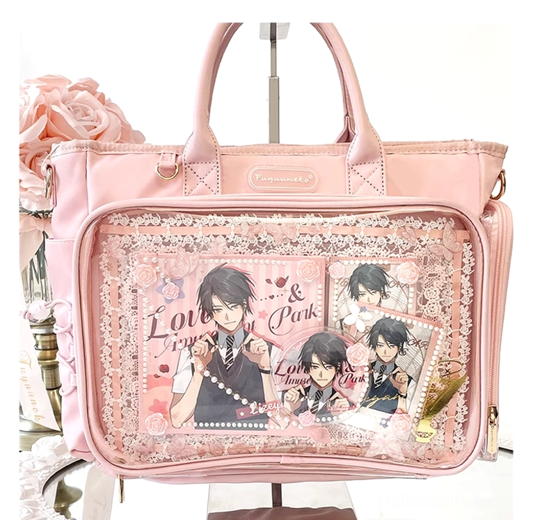 Pink Jirai Kei itabag with transparent anime character display window, lace trim, and decorative silk rose styling, flat lay overhead view