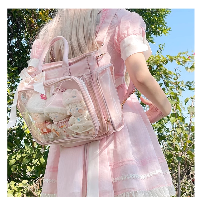 Pink Jirai Kei itabag back view on model in sunny outdoor garden as convertible backpack and shoulder bag with clear compartment containing plush dolls