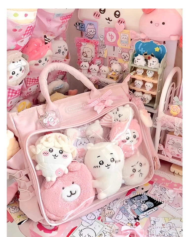 Pink Jirai Kei itabag high angle close-up with plush dolls positioned inside transparent compartment, multiple side storage pockets visible