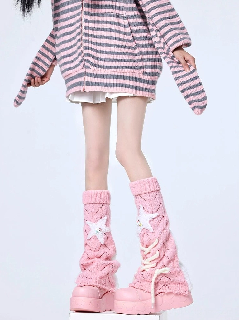 Side front view of blush pink Jirai Kei leg warmers with lace-up details and star decorations, coordinated with striped cardigan and pleated mini skirt plus pink platform heels for complete Y2K aesthetic