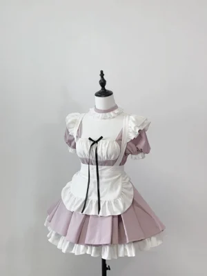 Pink Jirai Kei maid dress with detachable white apron flat lay display showing ruffled skirt design and black ribbon chest accent