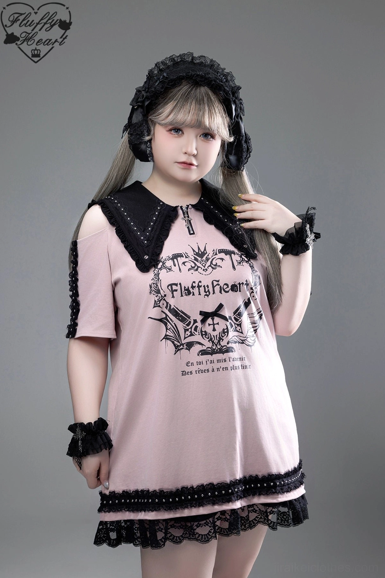 Pink off-shoulder Jirai Kei T-shirt dress with black pointed collar, lace-trimmed hem, gothic graphic print, and white wrist cuffs on blonde model with ruffled bonnet