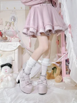 Pastel pink Jirai Kei platform chunky heel shoes with rhinestone buckle straps, paired with ruffled pink mini skirt in bedroom decor