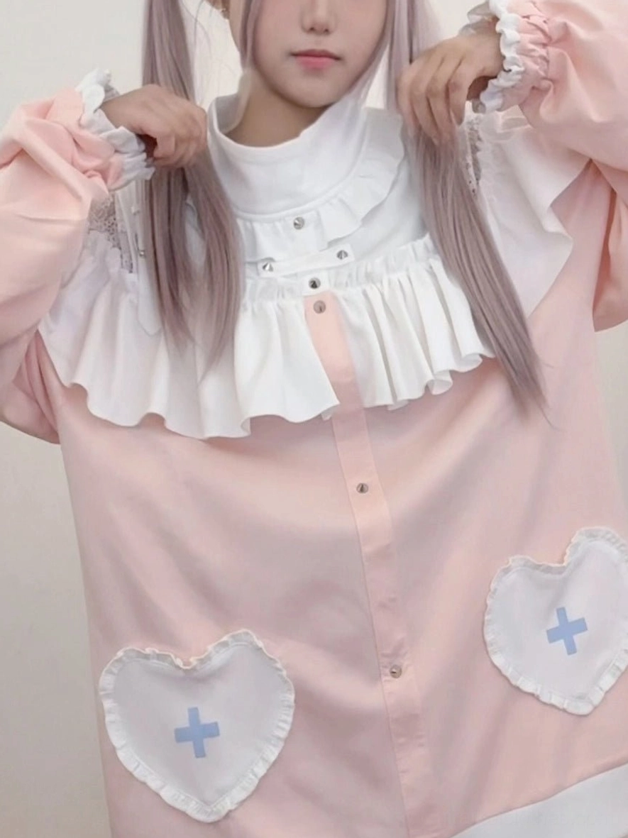 Detailed close-up front shot of Jirai Kei sweatshirt ruffled collar, heart-cross patch pockets and soft pink polyester fabric texture