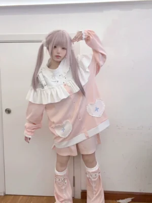 Pink Jirai Kei sweatshirt and shorts set with heart-cross pockets and white ruffled collar, worn with matching leg warmers in full-body front view, embodying sweet subculture fashion