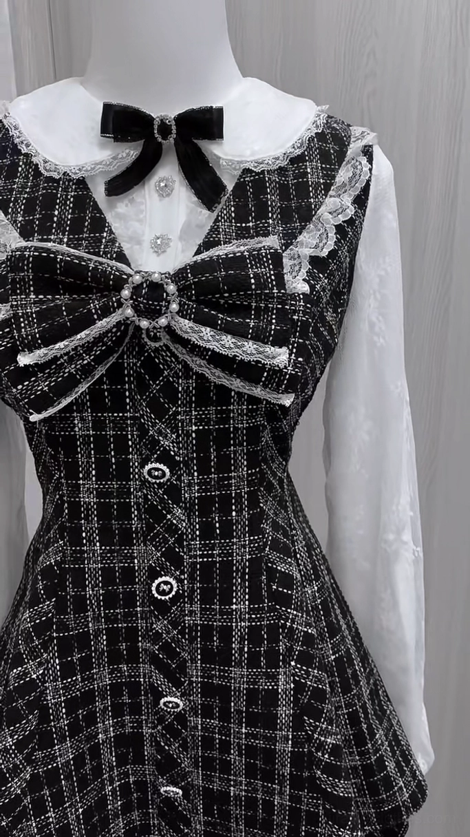 Upper portion of black and white plaid Jirai Kei dress featuring front button row, sparkling bow center detail, Peter Pan lace collar, and double-layer chiffon sleeve construction