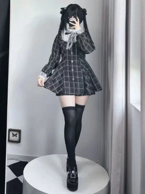 Black and white plaid Jirai Kei dress set front view with lace Peter Pan collar and heart-shaped button details worn by model with twin-tail hairstyle