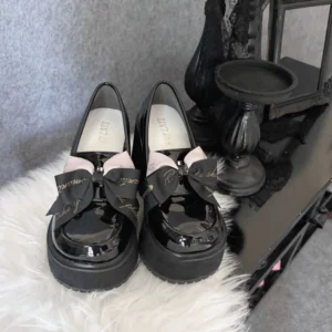 Black Jirai Kei lolita platform heels from angled front perspective displaying visible inner insole and architectural thick platform construction with glossy finish