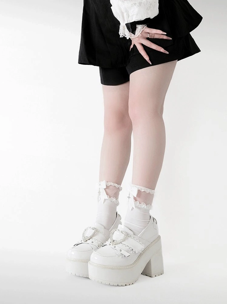 Detachable heart and cross-shaped ornaments adorning Jirai Kei platform loafers heel, showcasing customizable decorative accent design and aesthetic flexibility