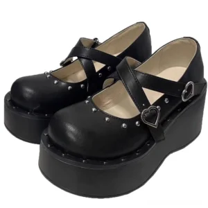 Black jirai kei platform mary jane shoes with heart-shaped buckles and cross straps, thick chunky wedge sole, front three-quarter view on white studio background