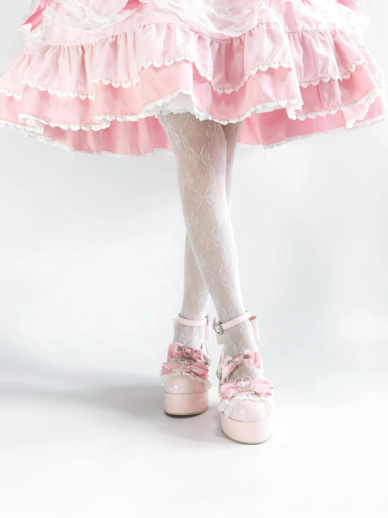 Multiple Jirai Kei platform Mary Jane shoes in different colors displaying satin bow decorations and heart-shaped rhinestone buckle details