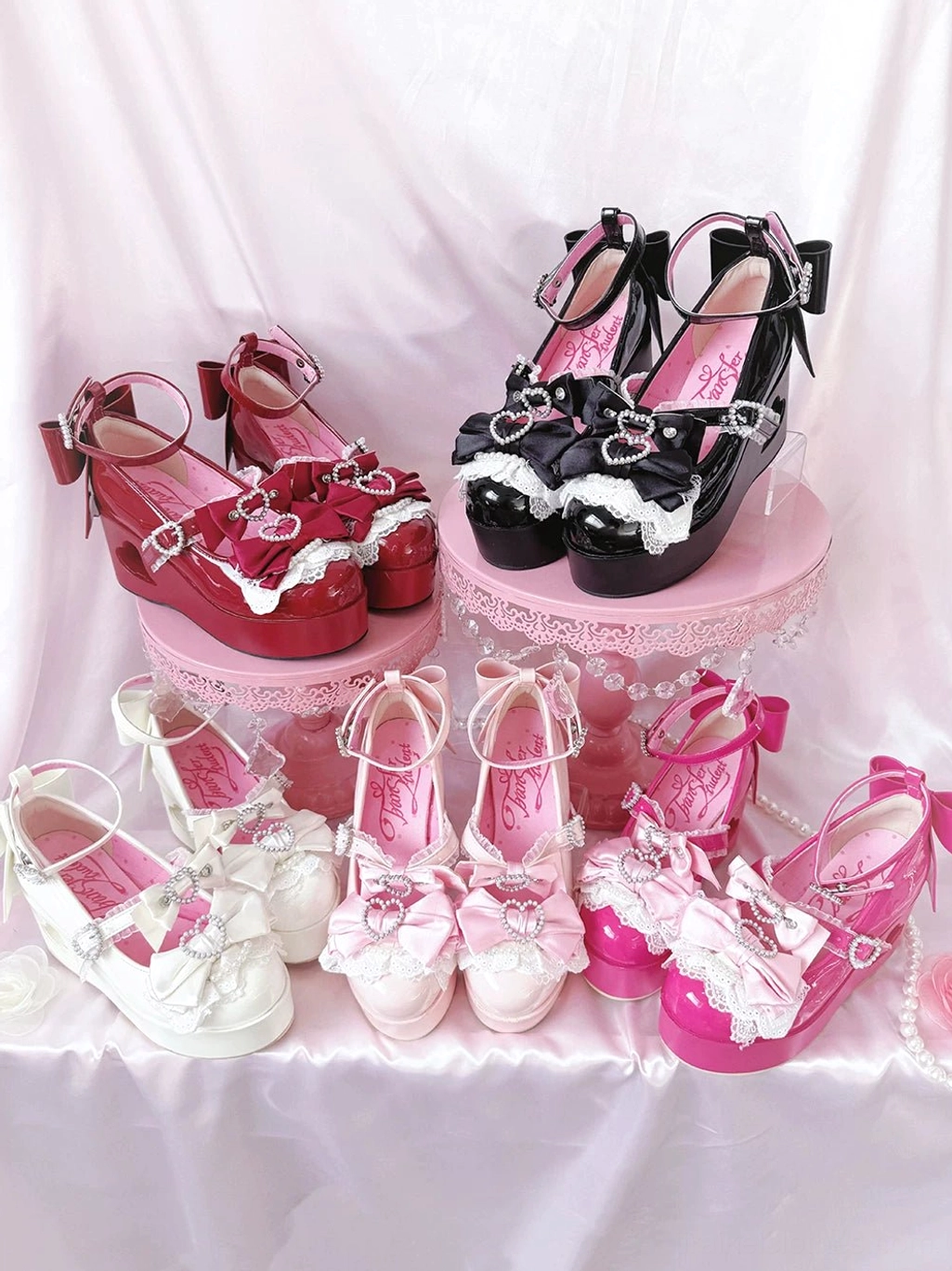 Four color variants of Jirai Kei platform Mary Jane shoes with heart-cutout heels and satin bow details displayed in flat lay arrangement
