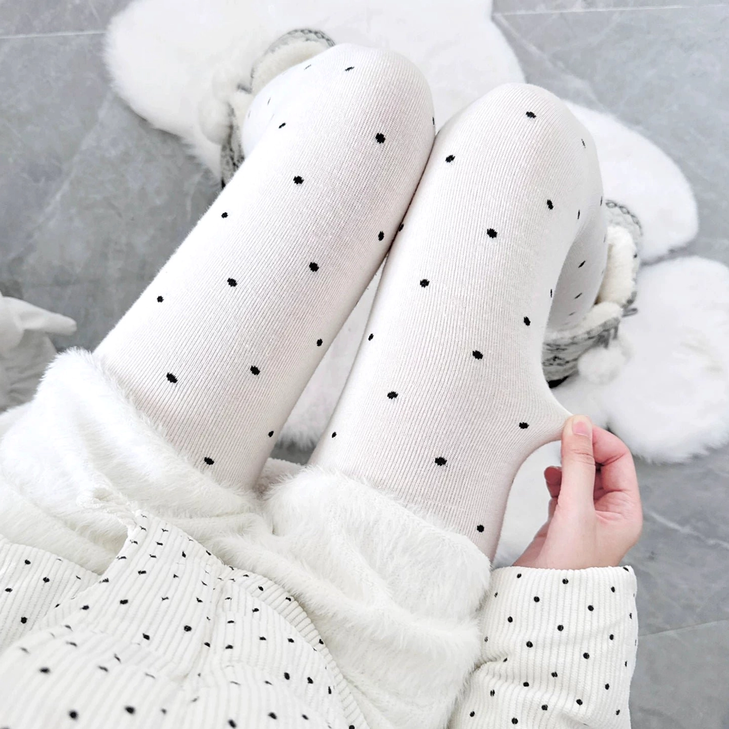 Polka dot footed tights worn with white polka dot pajamas, top-down close-up shot showcasing milky white base with tiny black polka dots, soft smooth fabric perfect for Jirai Kei home aesthetic