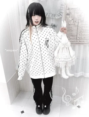 White polka dot Jirai Kei zip-up tracksuit set with black polka dots and contrasting details, relaxed fit on female model in home setting