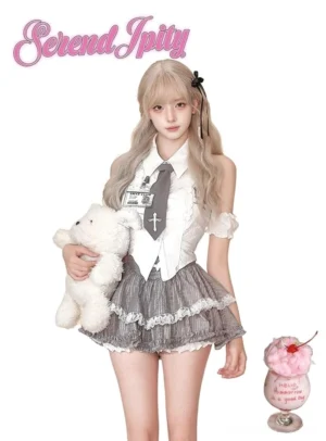 Jirai Kei preppy gyaru full-body outfit featuring blonde model wearing white embroidered halter blouse with cross necktie, detachable ruffled arm bands, gray plaid mini skirt with lace trim, styled with teddy bear and dessert props on pastel background