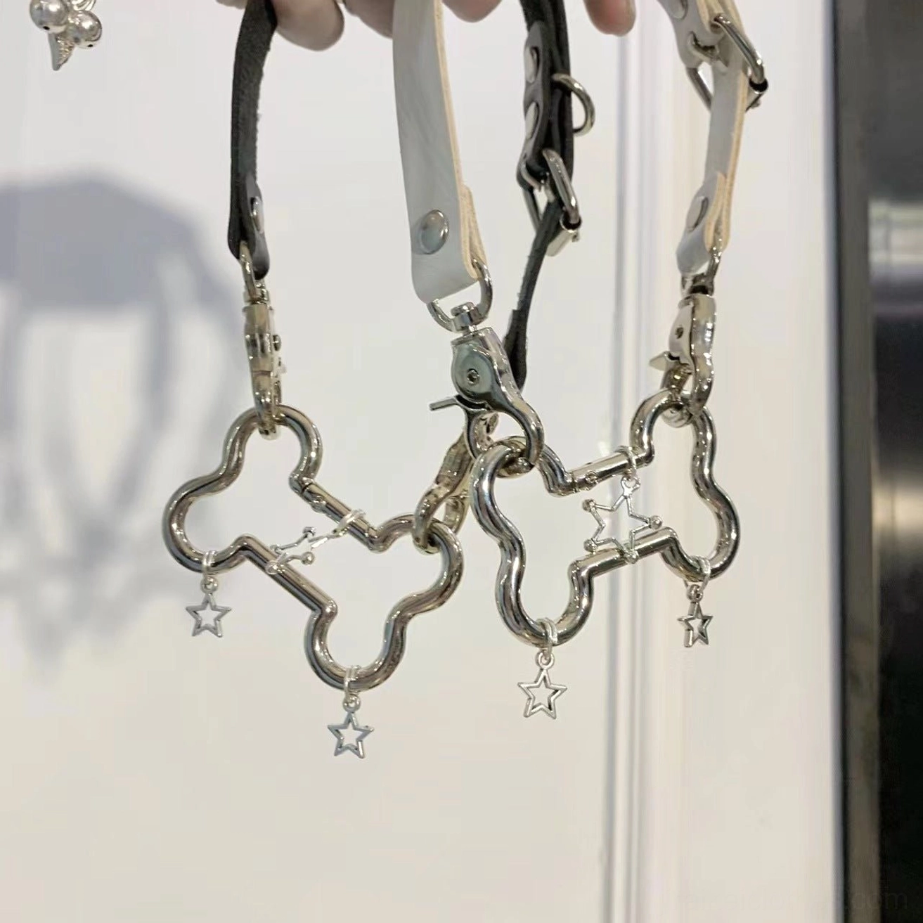 Dual punk choker necklaces featuring silver alloy bone links and star charm dangles in black and white polyurethane leather strap flat lay