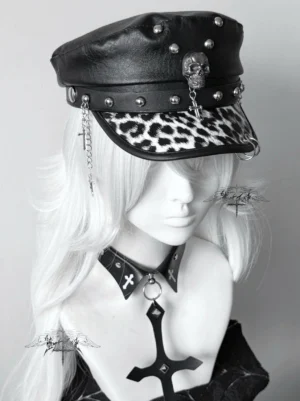 Jirai Kei punk leather newsboy cap with leopard print brim, metal studs, and skull cross pendant front three-quarter view on mannequin