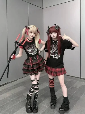 Matching punk gothic Jirai Kei duo outfits front full-body view featuring black-red color scheme strawberry chain graphic tees layered red plaid skirts and striped legwear