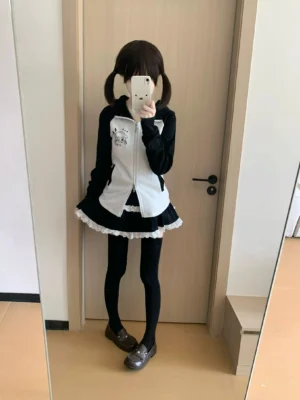 Black-white Jirai Kei hoodie jacket with puppy ear hood worn by model in mirror selfie, featuring drop shoulder design and color-block paneling