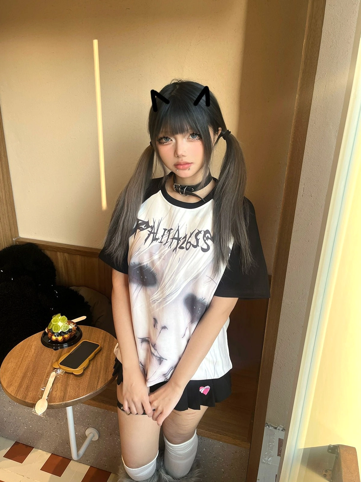 Jirai Kei raglan graphic T-shirt with anime face print on white body and black sleeves paired with mini skirt and socks styling