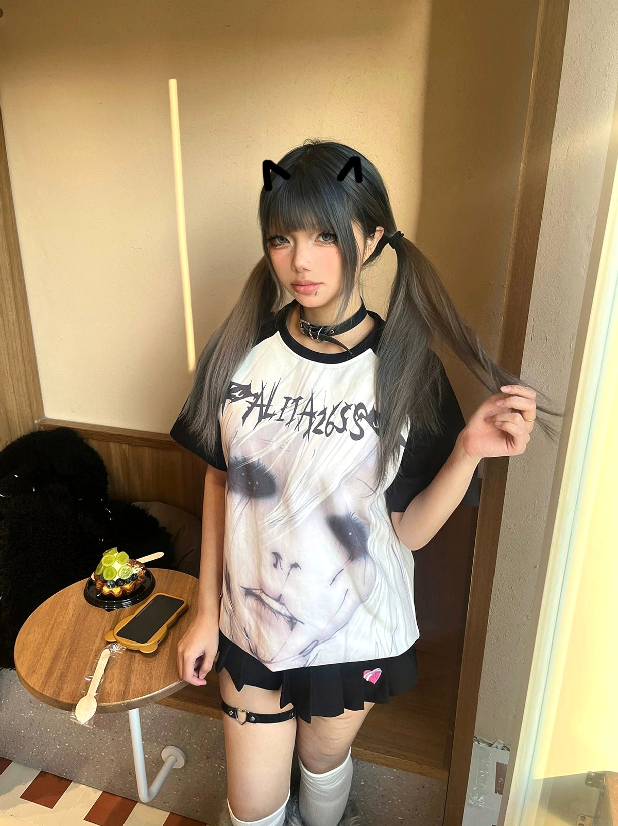 Loose-fit Jirai Kei gothic raglan T-shirt with ALITA26SS text print and black contrast sleeves worn indoors at café setting