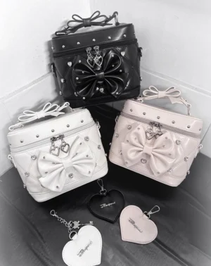Rhinestone heart lock Jirai Kei vanity box handbag top-down flat lay with bow decoration, rivets and heart-shaped lock on leather mat with heart keychains