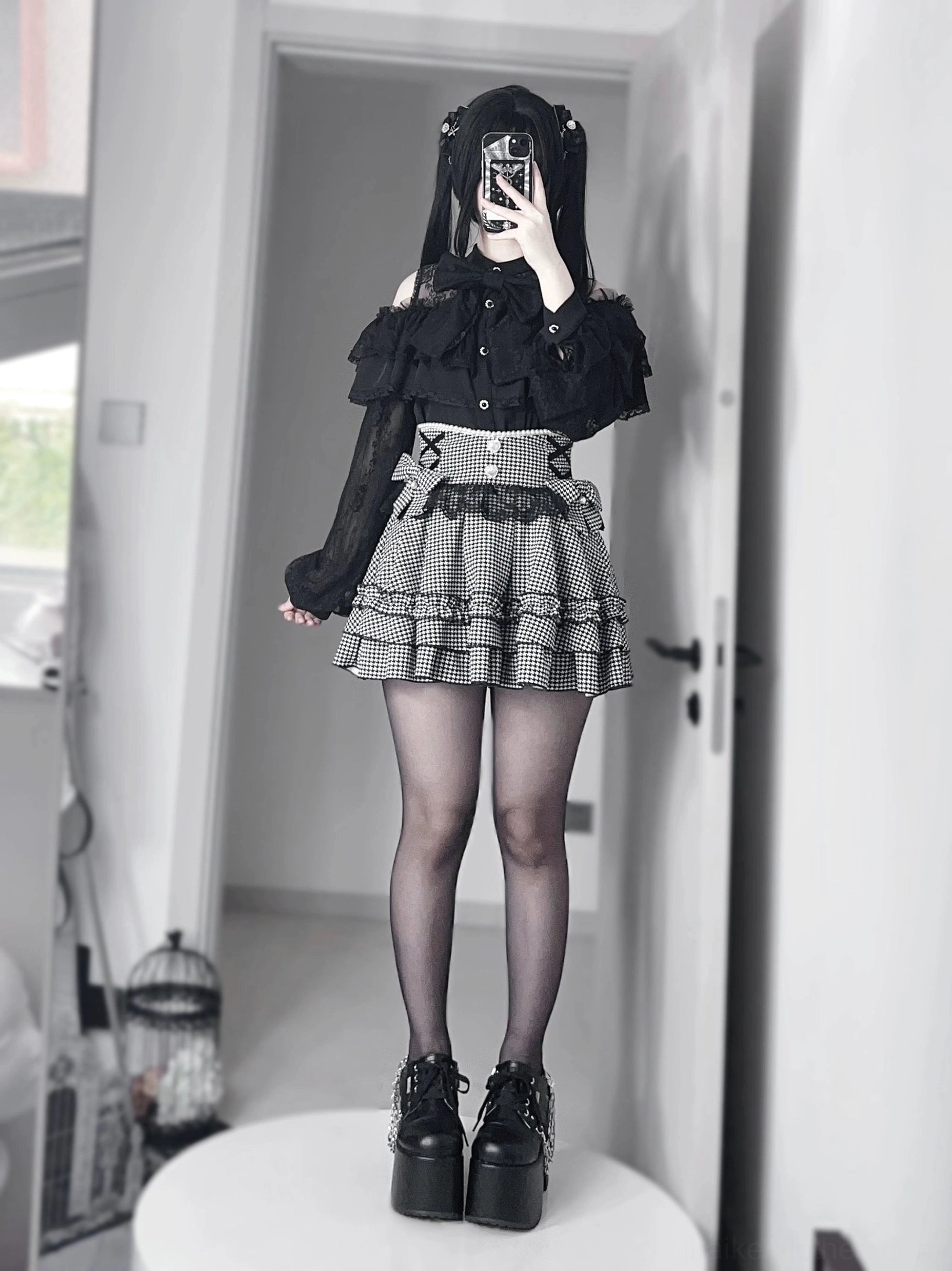 Jirai kei ruffle skirt back view showing shirring detail and ruffled hem, worn with black lace blouse and platform boots, hooded model