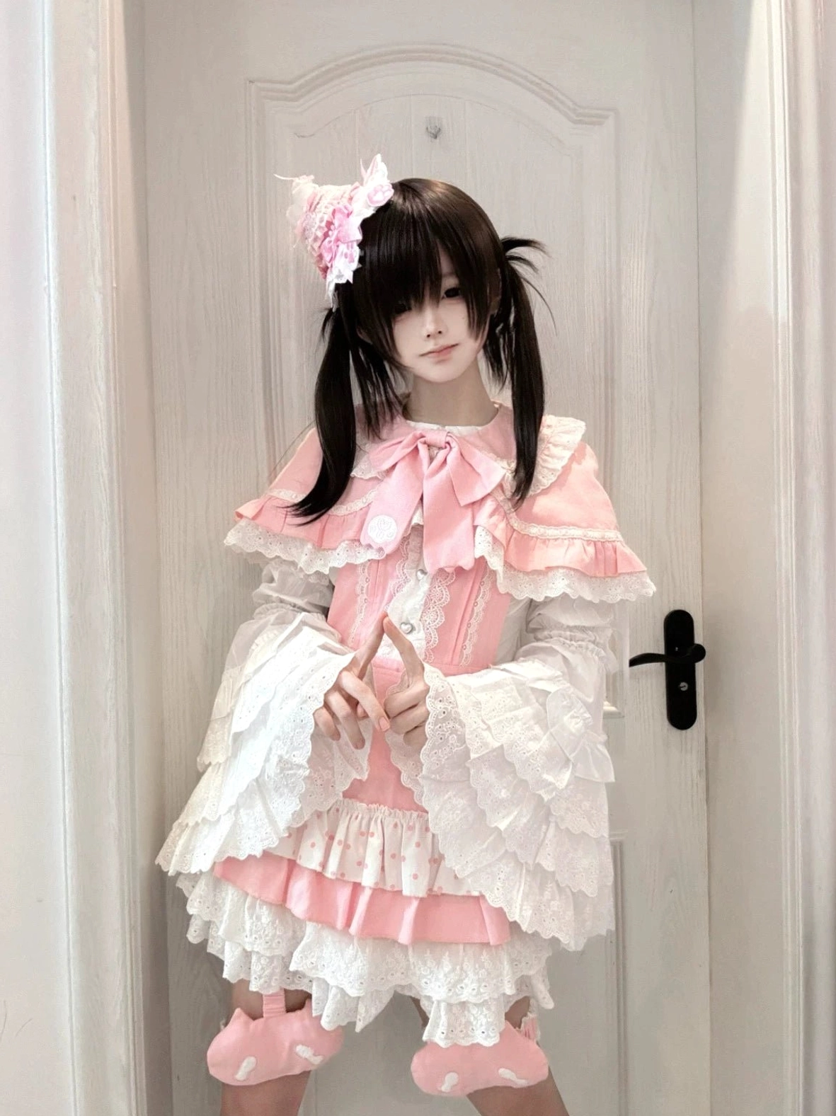 Ryousangata jirai kei dress set on model, pink and white suspender dress with tiered ruffle skirt, polka dot hem details, and ruffled leg warmers, complete casual lolita outfit