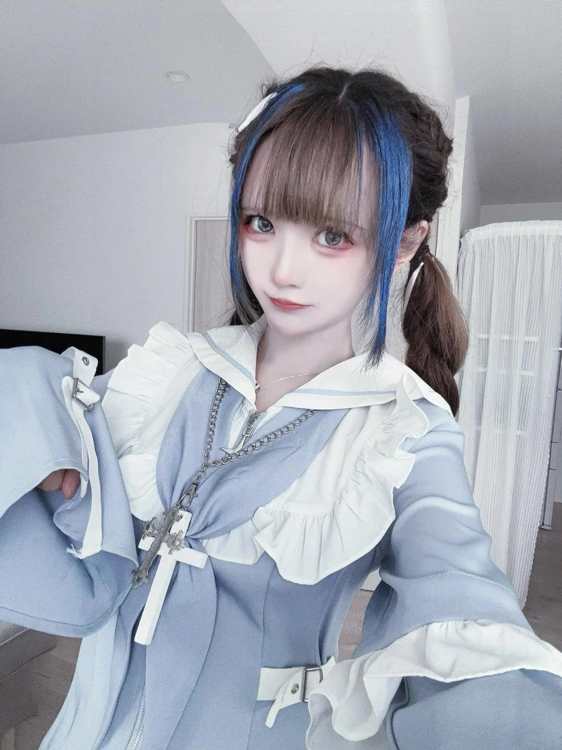 Model wearing pastel blue sailor Jirai Kei dress and shorts set with detachable full-length sleeves configured in extended position paired with platform shoes