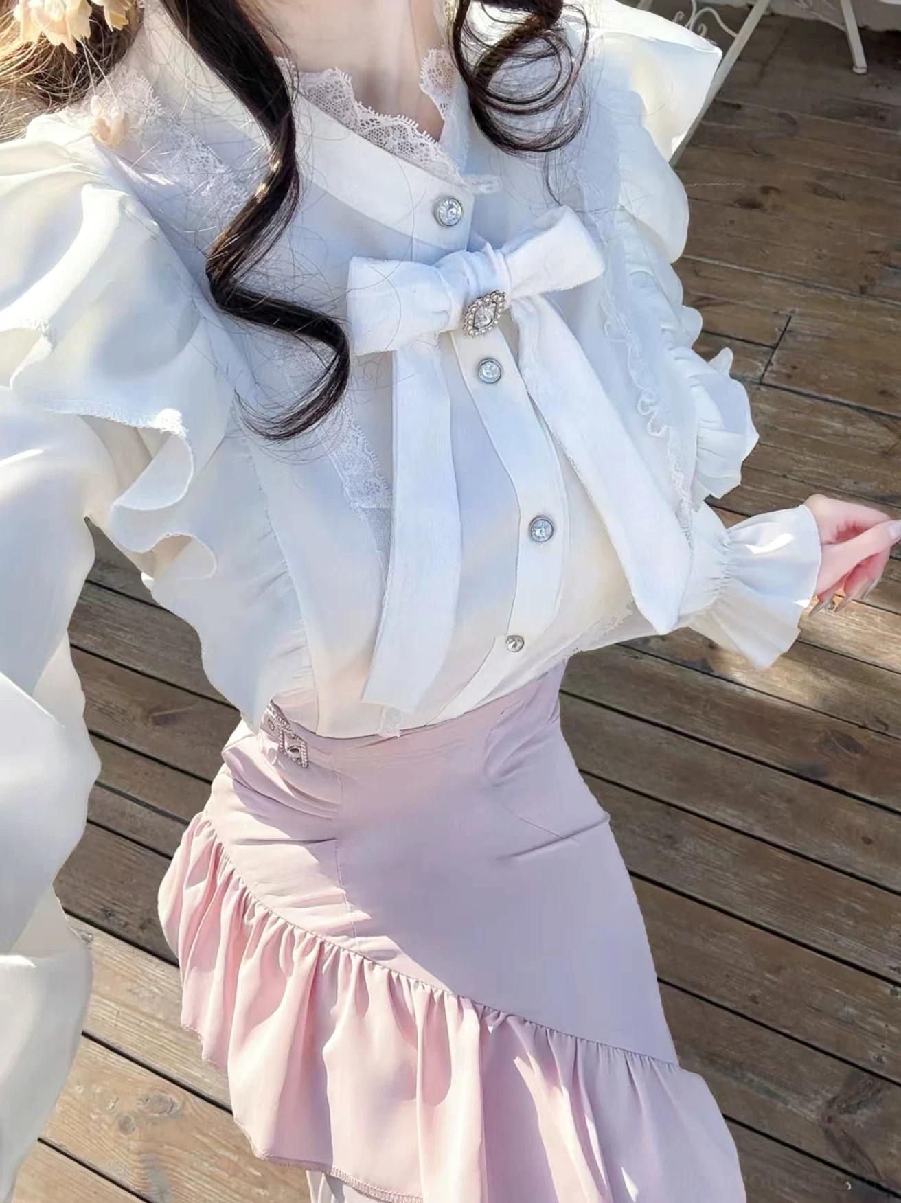 Front close-up detail shot of satin-like white blouse fabric and layered ruffle pink mermaid skirt hem showcasing Jirai Kei romantic texture and construction quality