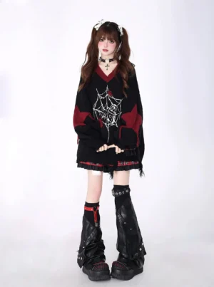 Black Jirai Kei spiderweb V-neck oversized sweater with five-pointed star patches and frayed plaid hem, worn by gothic model with twin ponytails in studio setting, front view