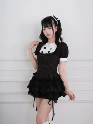 Three-quarter side view of black and white striped Jirai Kei outfit showing fitted bodice and side ribbon trim details on tiered skirt