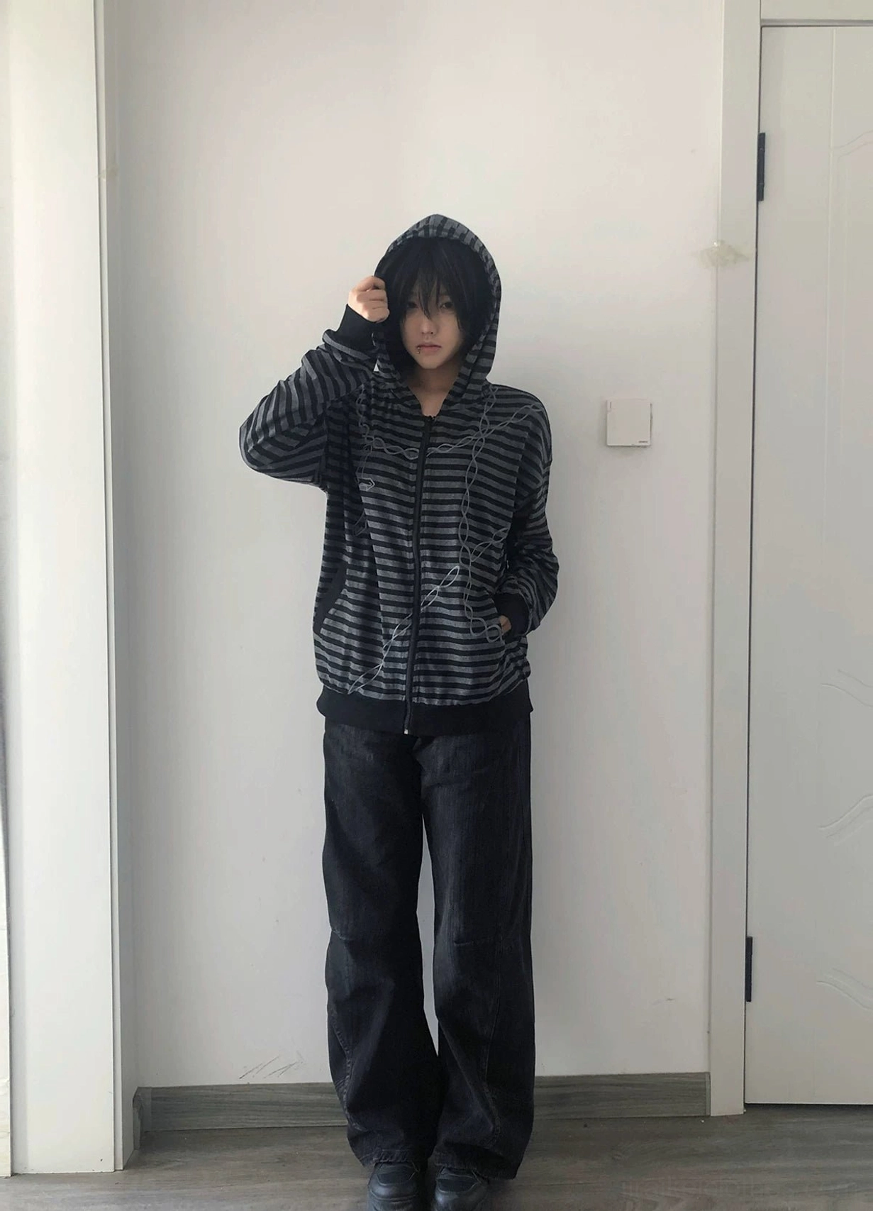 Dark aesthetic striped hoodie care and maintenance guide display showing washing ironing storage best practices