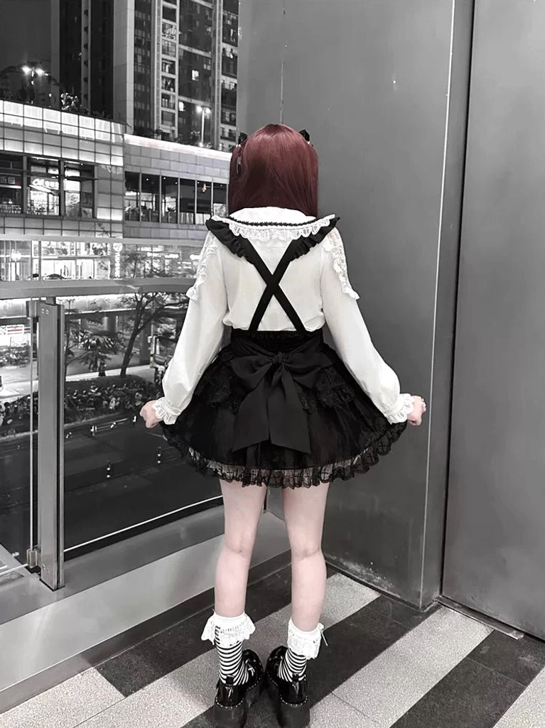 Jirai Kei suspender skirt back view cross-back straps black bow decor layered lace hem outdoor mall balcony