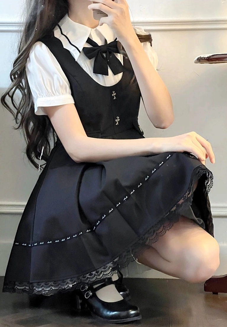 Jirai Kei suspender skirt detail shot showing cross-shaped buttons and pleated lace hem sitting pose