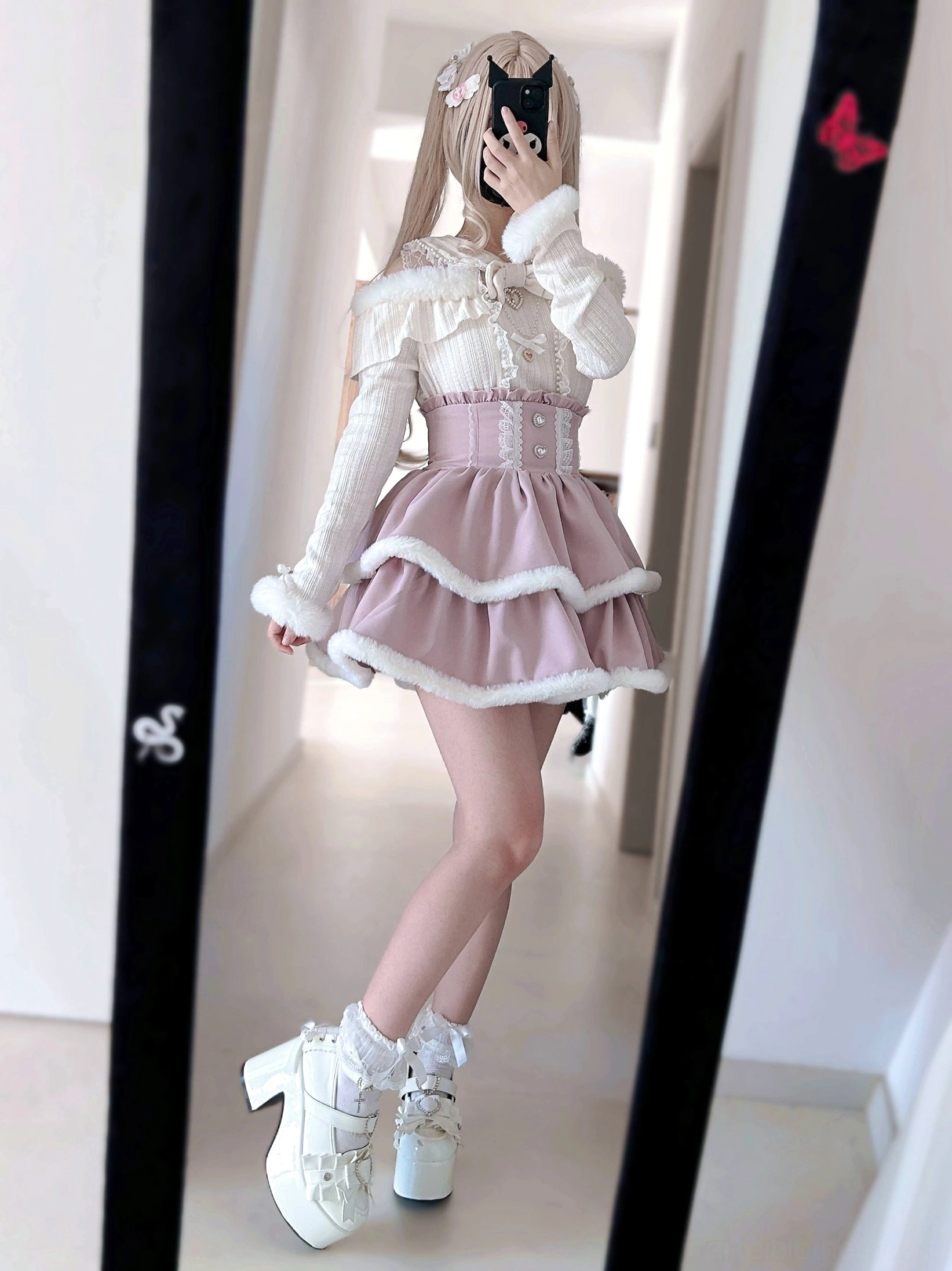Overhead flat lay of Jirai Kei knit sweater tops with pearl chain trim, heart-shaped buckles, lace and fuzzy collar details on fluffy fur rug background