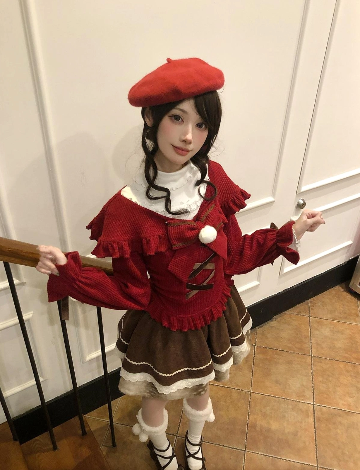Three-quarter side shot of jirai kei christmas outfit showing ruffled shoulder details, red beret, and brown skirt volume from stair railing perspective