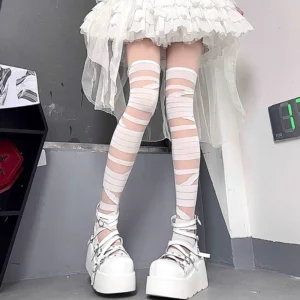 White Jirai Kei thigh-high bandage socks with winding wrap design worn with white ruffle skirt and platform shoes front leg view