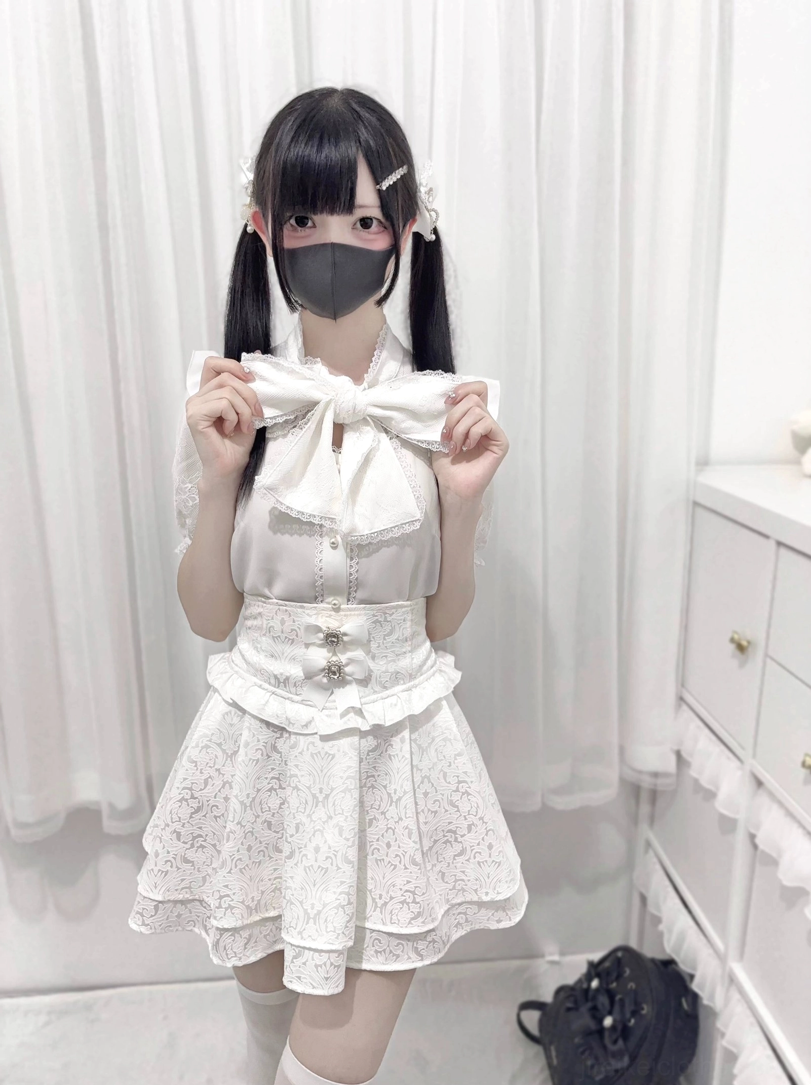 Jirai kei lace bow blouse white color front view holding decorative bow neckline detail ruffled lace skirt waist buttons