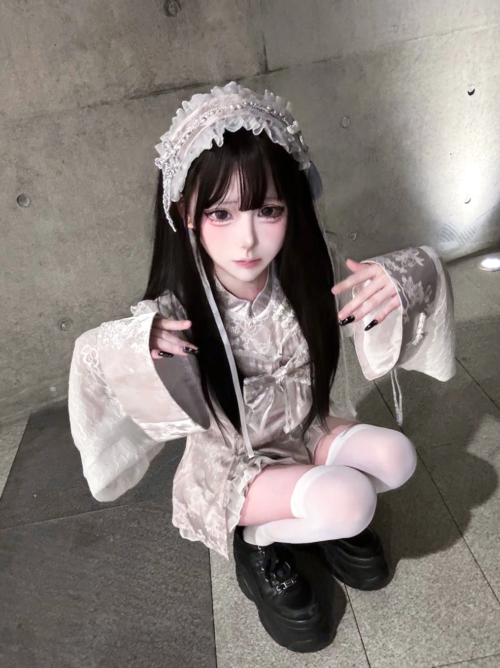 White ruffled hair headband modeled in squatting portrait, coordinated with pink Chinese Lolita outfit, Jirai Kei hair accessory styling demonstration, tones matching